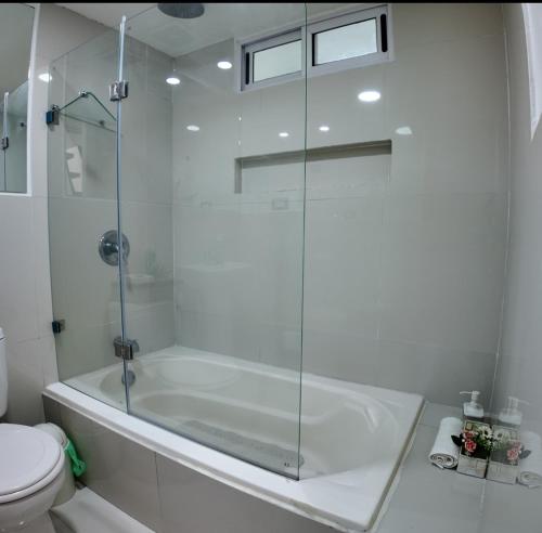een witte badkamer met een bad en een toilet bij Las Terrazas Suites Studio Apartment in San Salvador