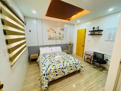 a bedroom with a bed and a desk in it at Santa Ana Transient House in Sampong