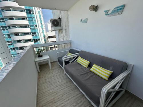a living room with a couch and a balcony at Escapada en Fragata Style con vista al mar in Cartagena de Indias