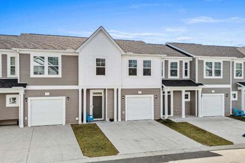 a large house with white garage doors at Little River 3BR Villa with Outdoor Movies & Fire Pit, Indoor Fire Place, Arcades, & Beach! in Little River