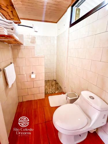 a bathroom with a white toilet and a window at Rio Celeste Dreams in Bijagua