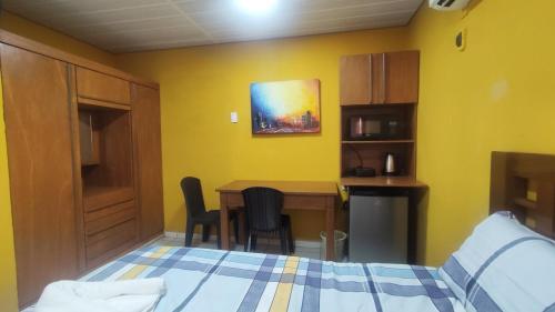 a bedroom with a bed and a table and a kitchen at Habitación Full en Santa Cruz - B in Santa Cruz de la Sierra