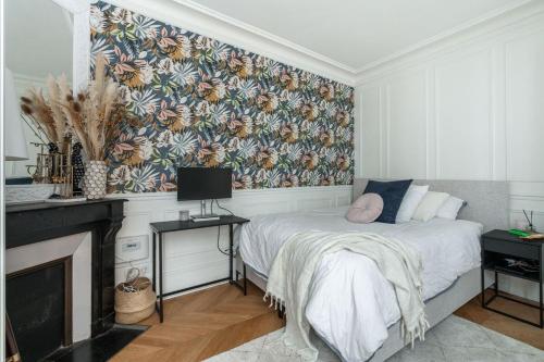 une chambre avec un lit avec un papier peint fleuri dans l'établissement Luxury Flat Montorgueil Le Marais Paris, à Paris