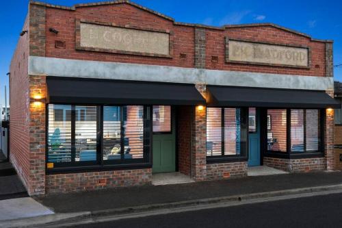a brick building with a sign that reads coogan at The Milliner on Elizabeth in Geelong West