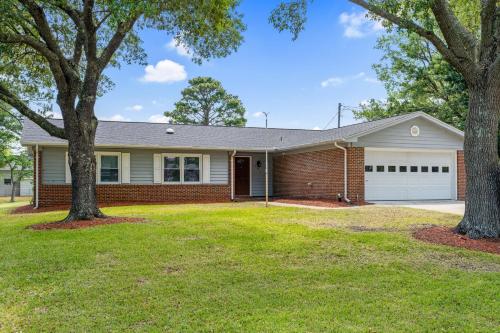 a brick house with a garage and two trees at Beach & Downtown Family Fun Wilmington Stay Villa in Wrightsville Beach