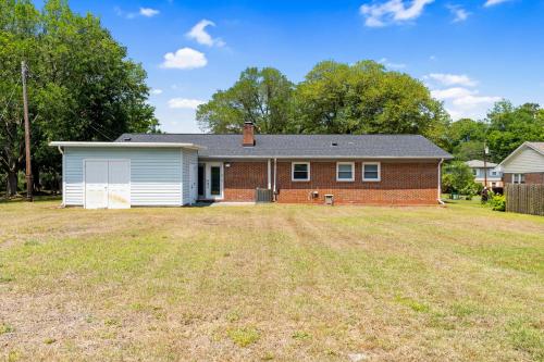 a brick house with a garage on a yard at Beach & Downtown Family Fun Wilmington Stay Villa in Wrightsville Beach