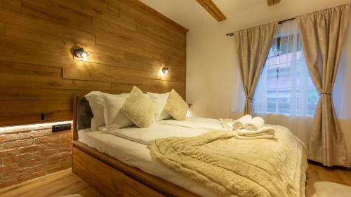 a bedroom with a bed with a wooden wall at Sun x Mountains - Old Town in Braşov