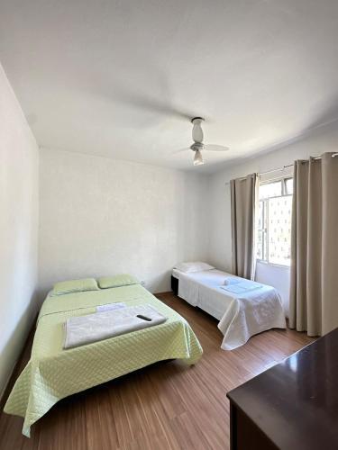 a bedroom with two beds and a window at Casa muito espaçosa com 3 quatos e churrasqueira in Juiz de Fora
