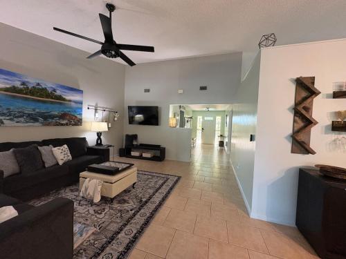 a living room with a couch and a ceiling fan at 10 Min from Beach, Private Pool with Lanai Palm Coast Family Home in Palm Coast