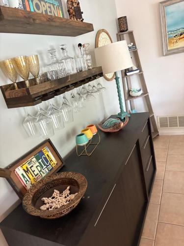 a room with a black dresser with a lamp and glasses at 10 Min from Beach, Private Pool with Lanai Palm Coast Family Home in Palm Coast