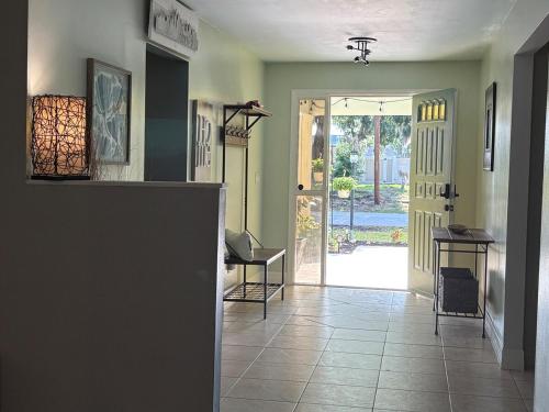 a hallway with a door leading to a yard at 10 Min from Beach, Private Pool with Lanai Palm Coast Family Home in Palm Coast