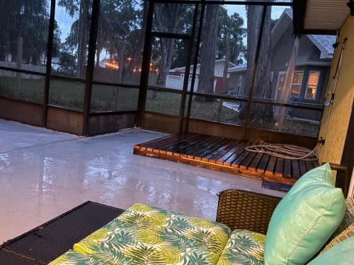 a screened in porch with a bed and a couch at 10 Min from Beach, Private Pool with Lanai Palm Coast Family Home in Palm Coast
