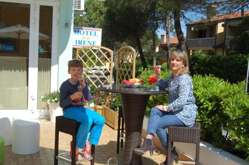a boy and a girl sitting at an outdoor table at Hotel Irene in Lignano Sabbiadoro