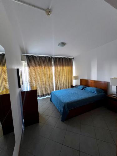 a bedroom with a blue bed and a window at Space atlantic 1 in Portimão