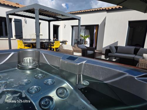a bath tub in the middle of a patio at Maison familiale en bord de mer avec JACUZZI in Vaux-sur-Mer