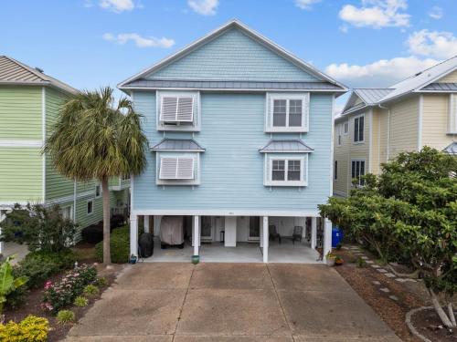 a blue house with white windows and a driveway at Steps to the Sand in Carolina Beach Sleeps 10 Villa in Carolina Beach