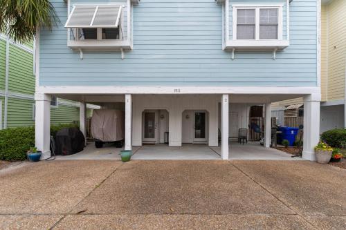 a blue house with a porch and a window at Steps to the Sand in Carolina Beach Sleeps 10 Villa in Carolina Beach