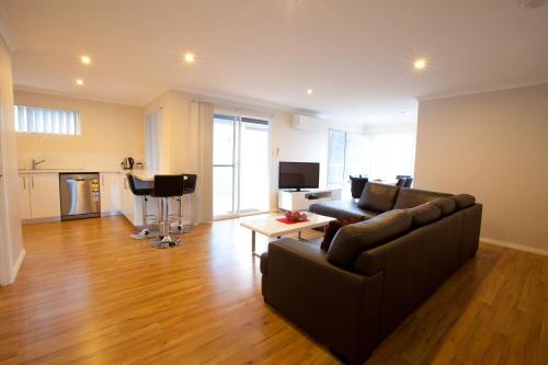 a living room with a couch and a table at Cape Villas in Dunsborough