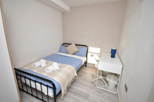 a small bedroom with a bed and a desk at Comfortable bedrooms in Kingston in Kingston upon Thames
