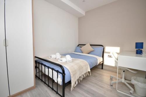 a bedroom with a bed with blue sheets and pillows at Comfortable bedrooms in Kingston in Kingston upon Thames