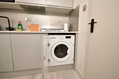 a laundry room with a washer and dryer at Comfortable bedrooms in Kingston in Kingston upon Thames