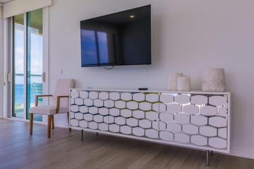 a white cabinet with a television on a wall at Azure Beach Residences in Palm-Eagle Beach