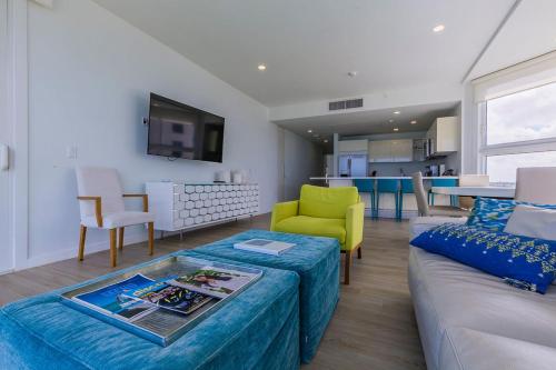 a living room with a couch and a table at Azure Beach Residences in Palm-Eagle Beach