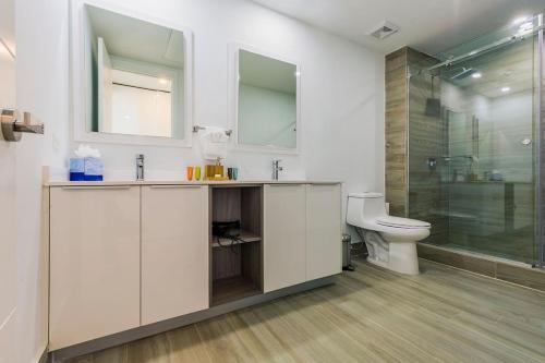 a bathroom with a toilet and a glass shower at Azure Beach Residences in Palm-Eagle Beach