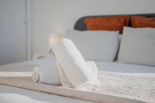 a pile of towels sitting on top of a bed at Tuam St Stay - 1BR with Balcony Bath in Christchurch