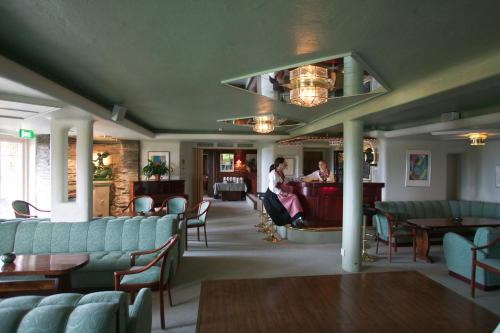 a woman sitting at a bar in a waiting room at Green Hotel in Tällberg