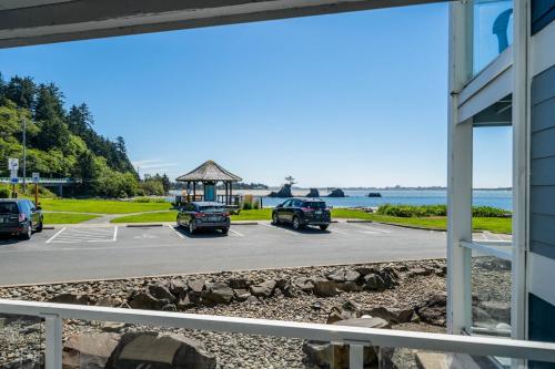 three cars parked in a parking lot next to the water at Waters Edge 103 in Lincoln City