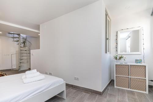 a white room with a bed and a mirror at Casa Largo, Town Centre in Tavira