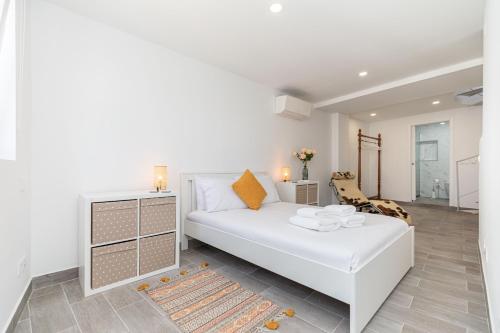 a bedroom with a white bed and a living room at Casa Largo, Town Centre in Tavira