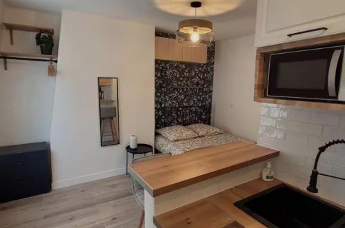 une chambre avec un lit et une télévision sur un mur dans l'établissement Charming and quiet Paris Studio, 10 min from Champs Elysees, à Paris