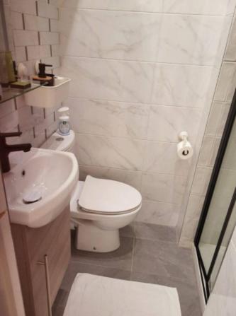 une salle de bain blanche avec des toilettes et un lavabo dans l'établissement Charming and quiet Paris Studio, 10 min from Champs Elysees, à Paris