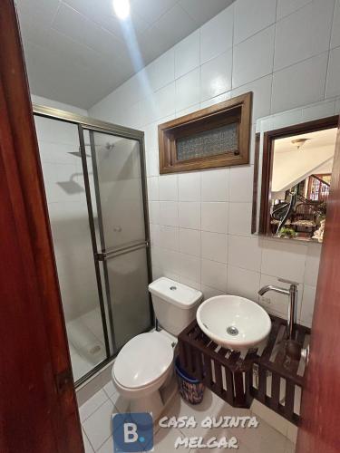 a bathroom with a toilet and a sink and a shower at Casa Quinta Melgar in Melgar