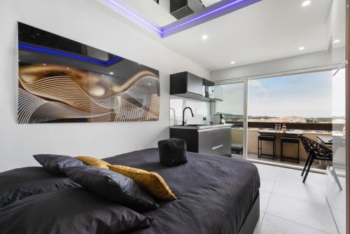 une chambre avec un grand lit et une cuisine dans l'établissement Village Naturiste R4N - Mask Off Room Port Nature, au Cap d'Agde