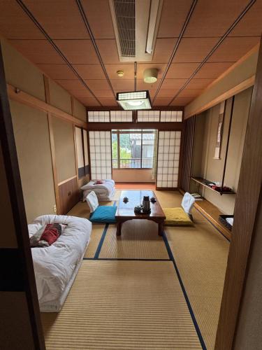 a room with two beds and a table in it at 川端屋　kawabataya in Minamiechizen