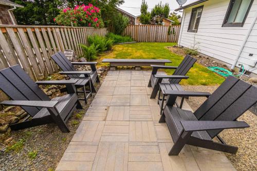 a group of chairs and tables in a backyard at Cozy Cove Cottage in Seaside