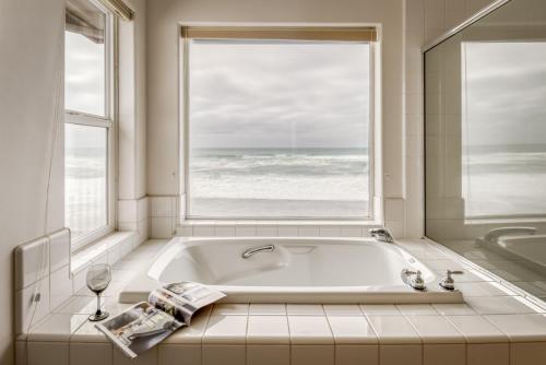 un bagno con vasca e ampia finestra di Oceans Song a Lincoln City