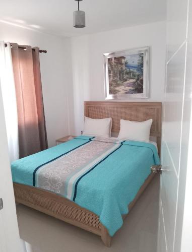 a bedroom with a bed with blue sheets at Ligas Mayores Residence in Boca Chica