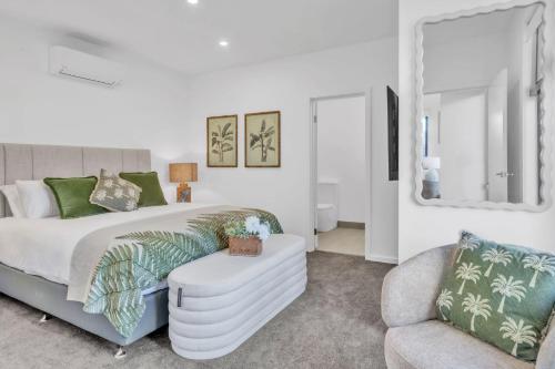 a bedroom with a bed and a couch and a chair at Birdsong Beach Retreat - Newly Built in North Creek