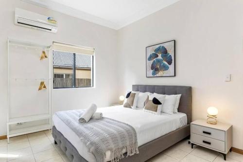 a bedroom with a large bed and a window at Cheerful Two Bedroom house in Sydney