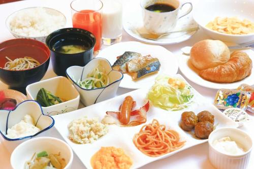 a table with plates of food and cups of coffee at Hotel Crown Hills GOI in Ichihara