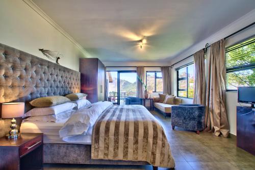 a bedroom with a large bed and a living room at Dreamhouse Guest House in Hout Bay