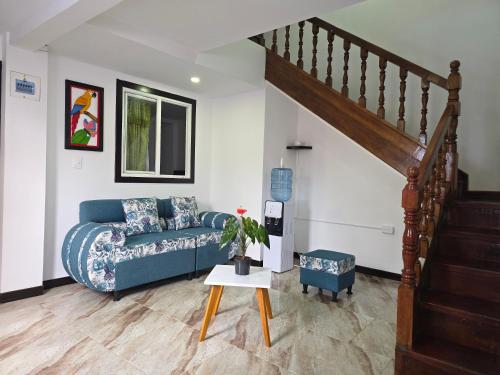 a living room with a blue couch and a staircase at Hotel El Buen Descanso in Filandia