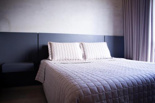 a bedroom with a bed with two pillows on it at Apartamento Loft Lazer Completo in Belo Horizonte