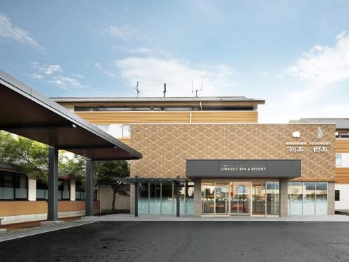 an empty parking lot in front of a building at ジュラシック スパ &リゾート くつろぎの宿 樹楽 in Toon