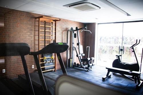 a gym with two tread machines and a brick wall at Apartamento Loft Lazer Completo in Belo Horizonte