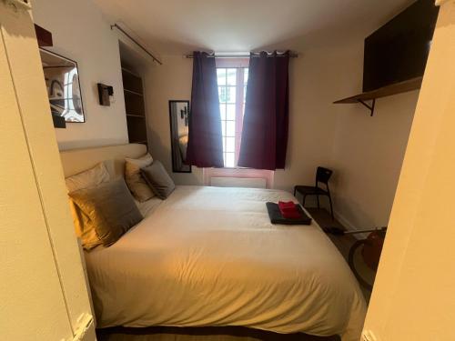 une chambre avec un lit blanc avec une fenêtre dans l'établissement Petit Dupleix atypique Porte Maillot F3, à Paris